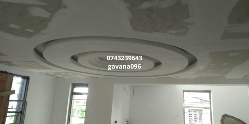 A detailed shot of a recently installed gypsum ceiling. There is a watermark on the image of the worker's name and number.